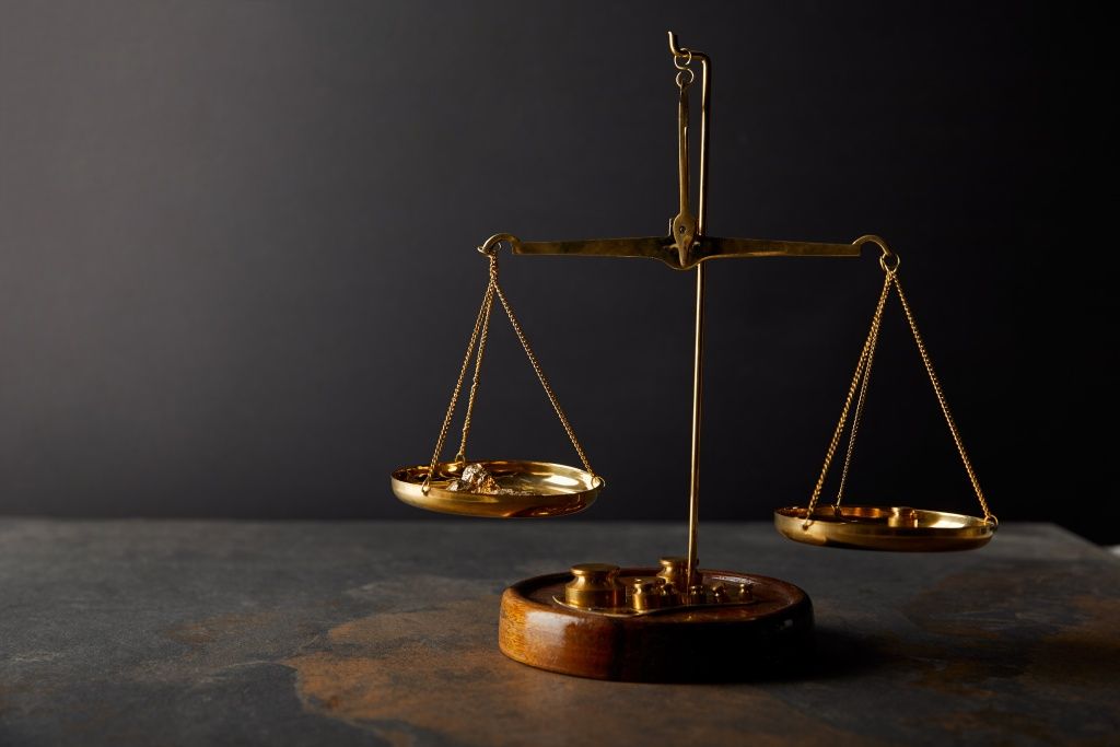 golden-stones-on-scales-on-marble-table-and-dark-b-2024-11-18-07-15-54-utc.jpg