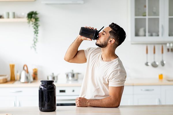 young-arab-guy-drinking-protein-shake-from-bottle-2023-11-27-05-02-23-utc.jpg