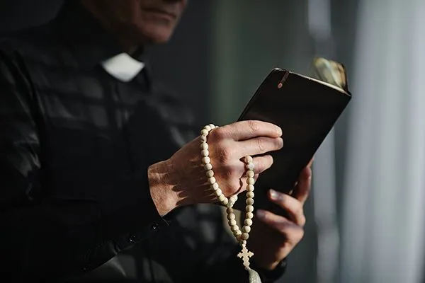 closeup-of-unrecognizable-priest-holding-bible-and-2023-11-27-04-59-31-utc.jpg
